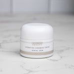 A jar of Hydrating Ceramide Cream sitting on a granite bathroom countertop - Amy Myers MD